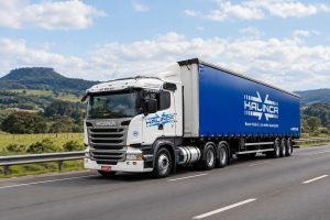 Caminhão da frota Kalinca Logística trafegando em autoestrada no interior do RS - montagem